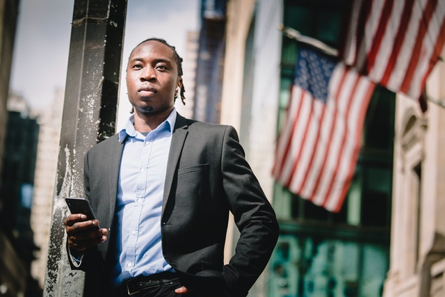 A man in suit and tie holding a cell phone.