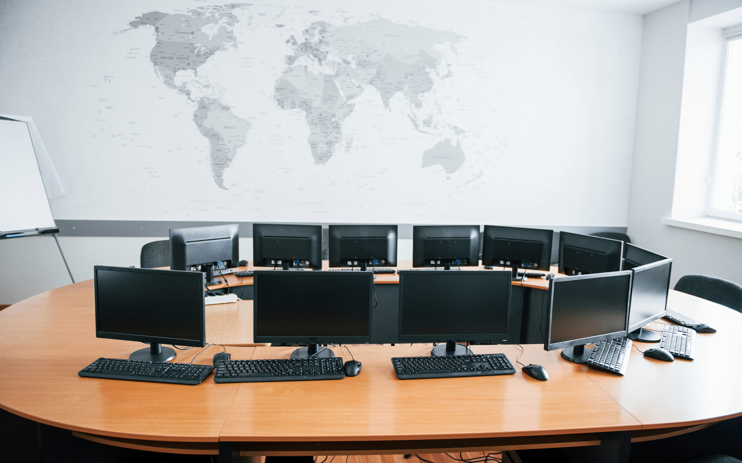 A conference room with multiple computers and keyboards.