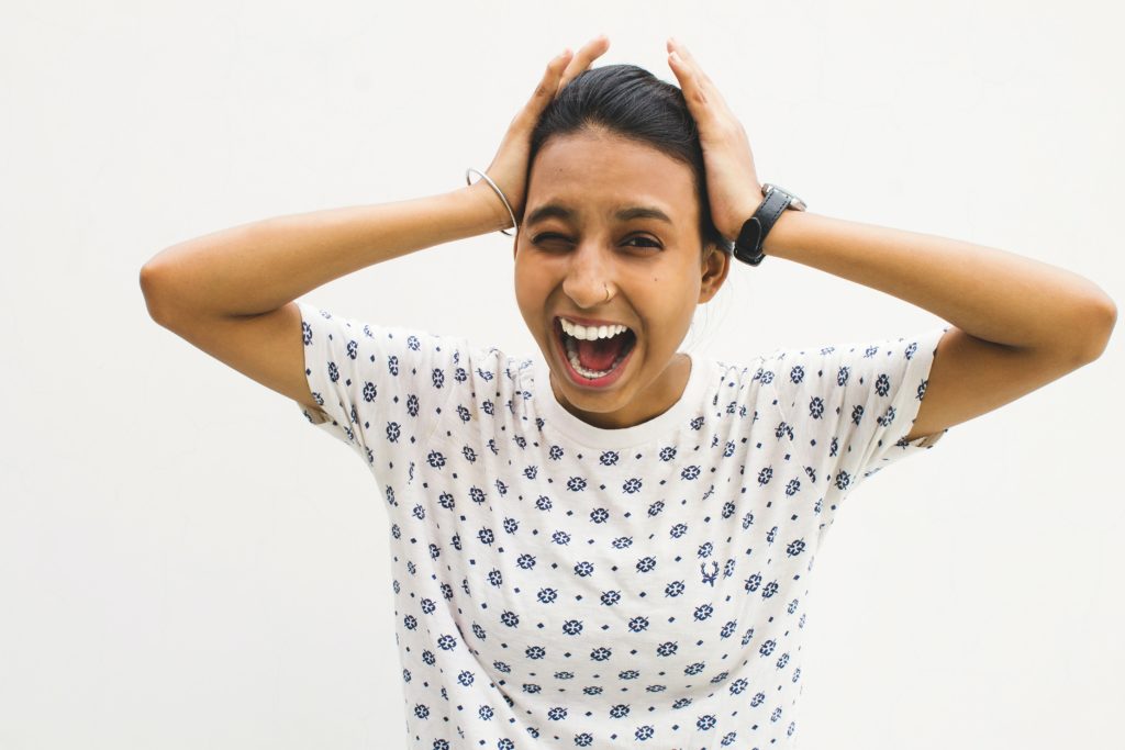 A woman is holding her head in the air.