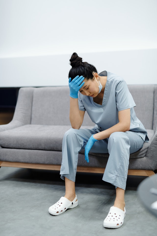 A woman in scrubs sitting on the couch